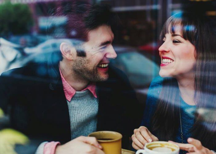 couple drinks coffee behind the glass