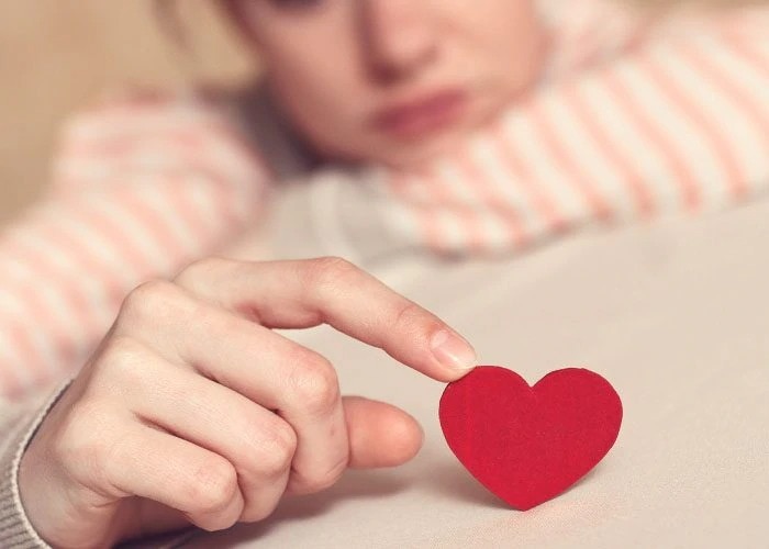 sad woman with paper heart