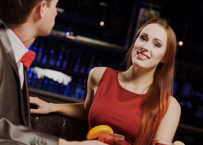 woman in red dress and man drinks cocktails