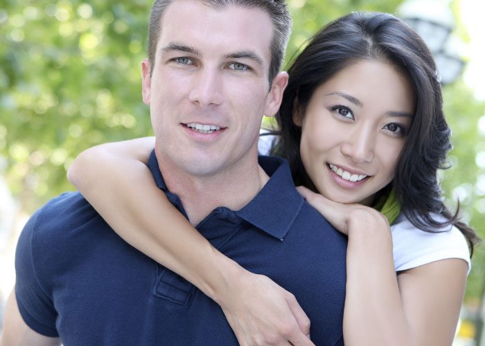 asian woman hugs white man