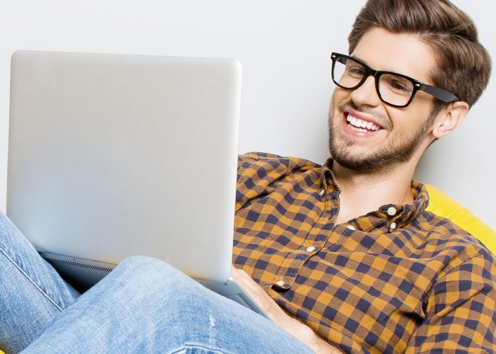 happy guy in glasses with laptop